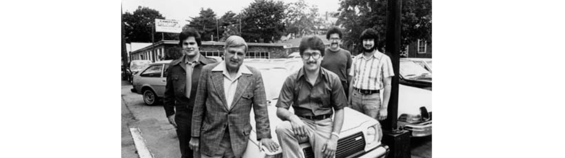 Ralph's Auto Sales staff beside cars in 1970