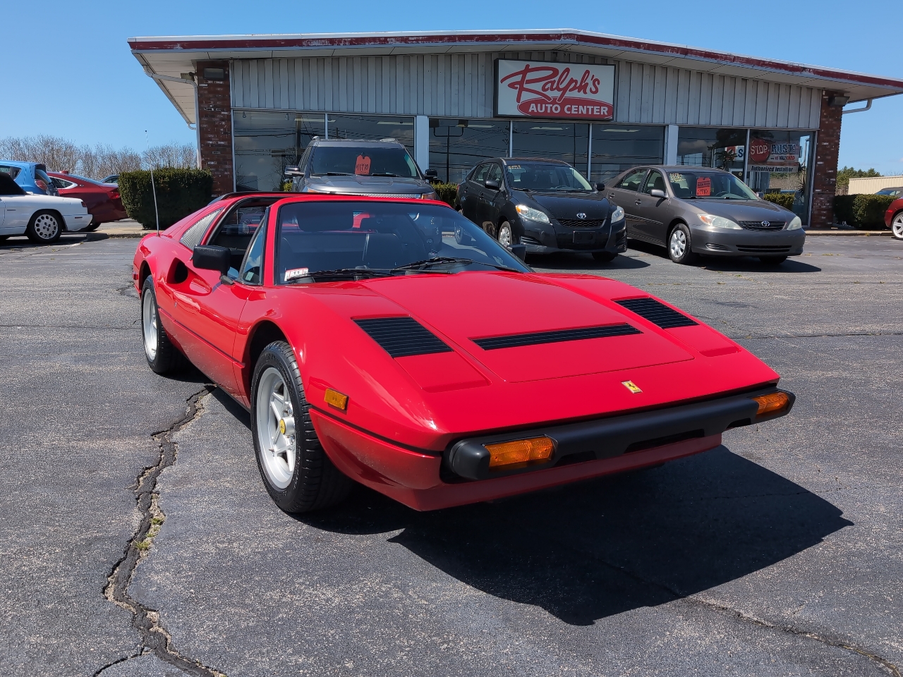 Red 1985 Ferrari 308 Quattrovalvole parked in front of Ralph's Auto Center